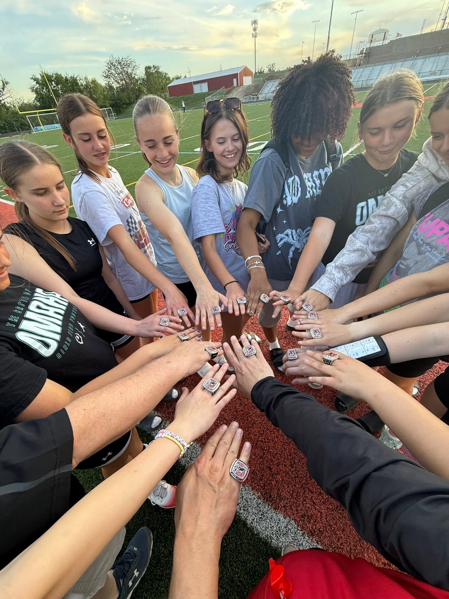 Jr. Stockmen athletes and coaches showing their championship rings together